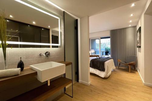 蒙得维的亚Apartamento deluxe en Pocitos_Life Veintiseis Apartments的一间带水槽的浴室和一间带一张床的卧室