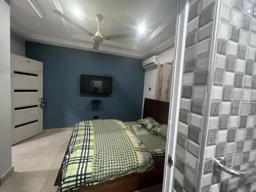 阿克拉T-Roys Apartments的一间卧室配有一张床和吊扇