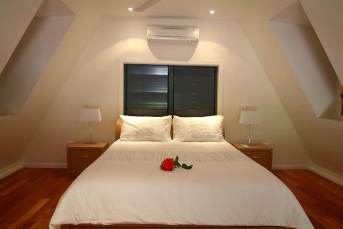 耐莉湾Canopy Chalet 4的卧室配有白色的床,床上有花