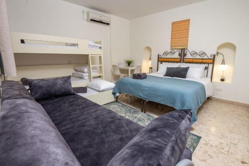 萨法德Family Villa - Prime Location Old City的一间卧室配有一张床、一张沙发和双层床。