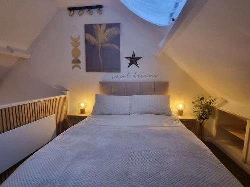 彭布罗克Cosy Moat House Cottage #3的卧室配有一张带两个灯的大白色床