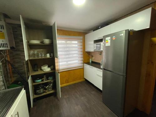 纳塔列斯港Casa en Puerto Natales的厨房配有不锈钢冰箱和木地板