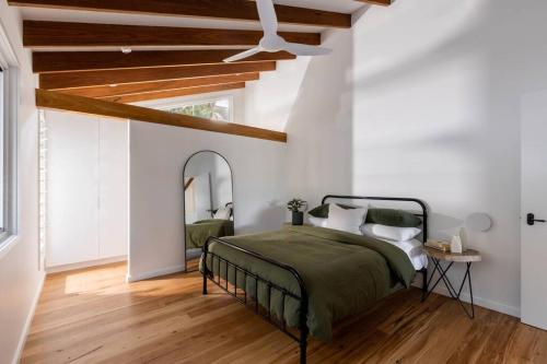 萨福克公园Blackbutt House - Luxe Family Retreat With Pool的一间卧室配有一张床和镜子