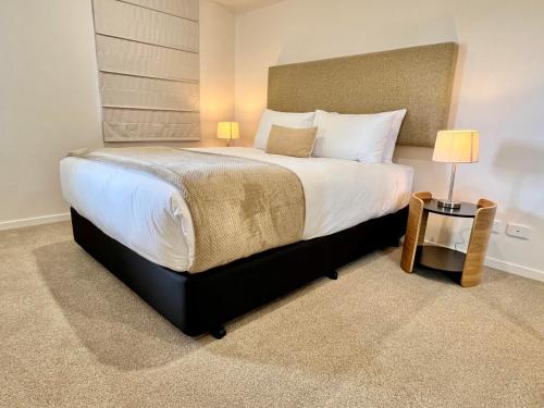 霍巴特Sixty Six Boutique Apartments的卧室配有一张带白色床单和枕头的大床。