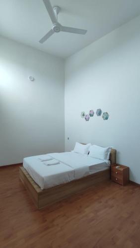 务边Gopeng Serumah Holiday House的一间白色卧室,配有床和天花板