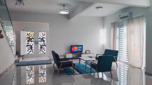 务边Gopeng Serumah Holiday House的客厅配有桌椅和电视