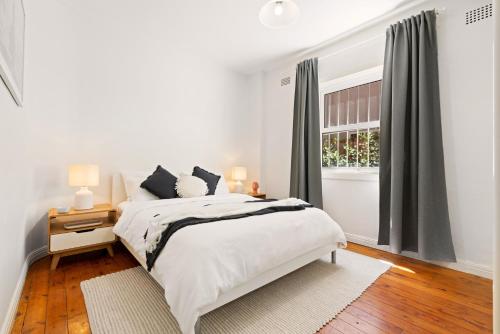悉尼Beach-side North Bondi的白色的卧室设有床和窗户