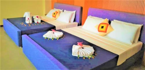 阿努拉德普勒Sooriya Wessagiri Resort的一间卧室配有两张单人床和色彩缤纷的枕头