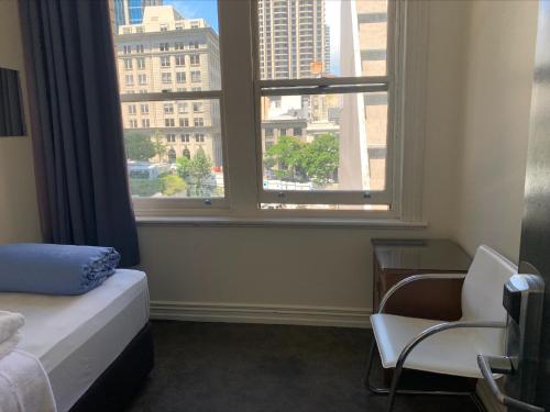奥克兰Fort Street Accommodation的一间卧室配有一张床、一张书桌和一个窗户。