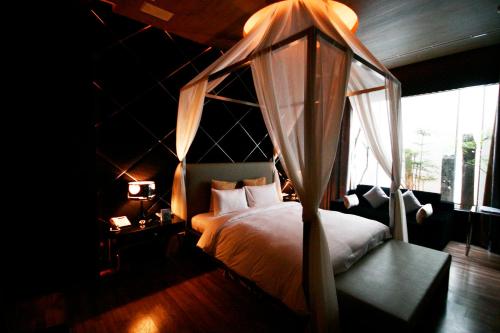桃园市约客顶级汽车旅馆的一间卧室设有天蓬床和窗户。