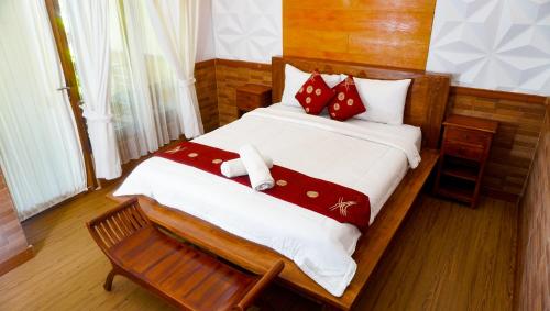 珀尼达岛La Nusa Penida Homestay的一间卧室配有一张带红色枕头的大床