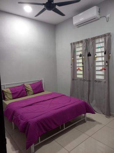 巴特沃思Yaths homestay的一间卧室配有一张紫色的床和吊扇