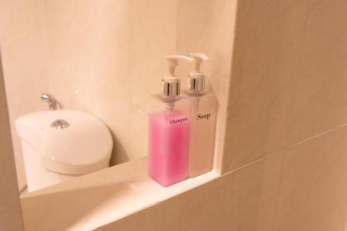 乌隆他尼President Hotel Udonthani的浴室内的一个架子上放着几瓶肥皂