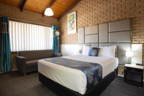 斯托尔Goldfields Motel的酒店客房配有床、沙发和椅子