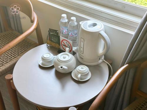 大叻Cherry Luxury Hotel的茶壶和茶杯的桌子