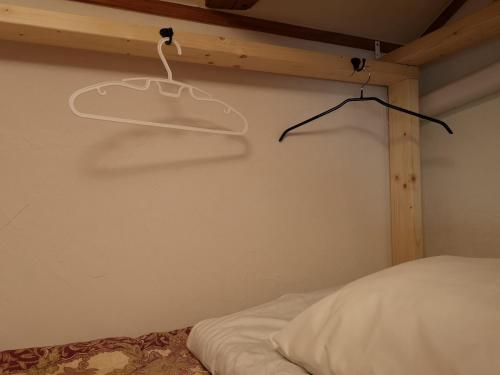 美祢Guest House Himawari - Vacation STAY 32621的卧室配有一张床和墙上的衣架