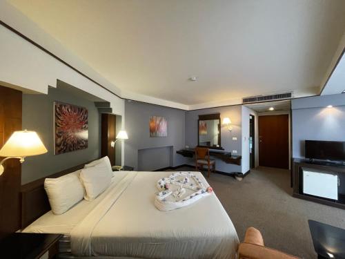 素攀武里松法布里酒店的酒店客房,配有床和电视