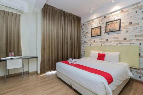 玛琅RedDoorz Plus at Riverside Malang的卧室配有红色色调的大型白色床