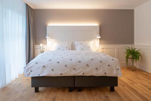 巴特利本采尔OSCARS Hotel 1415的卧室配有一张带白色棉被的大床