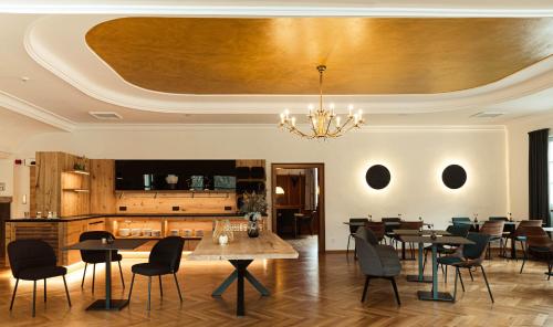 巴特利本采尔OSCARS Hotel 1415的一间带桌椅和天花板的用餐室