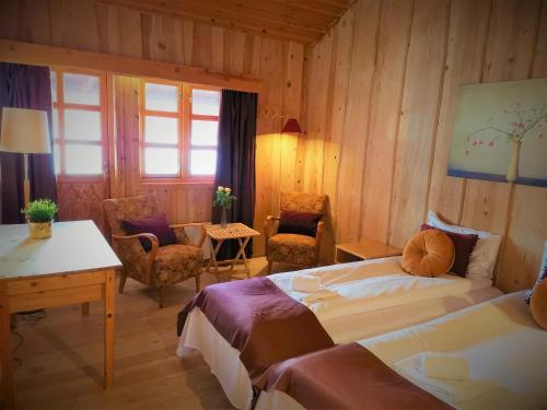 LeiraRingholmen Sjøhus的酒店客房带两张床和一张桌子以及椅子。