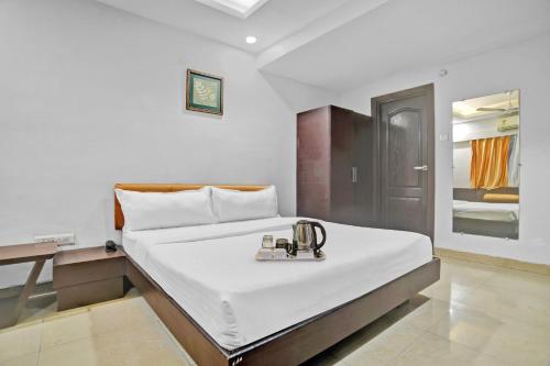 印多尔Townhouse Hotel Divya Palace的一间酒店客房,配有一张带托盘的床