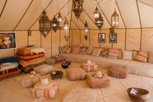 梅尔祖卡Beldi camp的带沙发和枕头的客厅(位于帐篷内)
