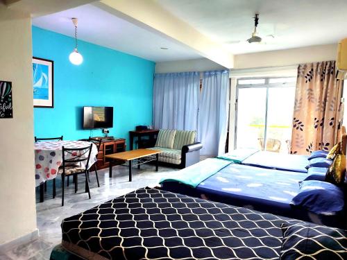 Kampong Tanah Merahseaview studio ocean view resort的一间拥有蓝色墙壁的卧室,配有一张床和一张桌子