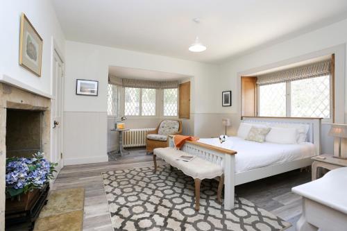 北贝里克The Lodge At Gilmerton House, North Berwick的一间卧室设有一张床,客厅设有壁炉。