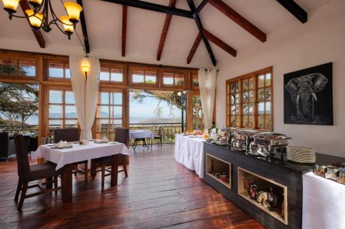 恩戈罗恩戈罗Lions Paw Ngorongoro的一间带桌子和壁炉的用餐室