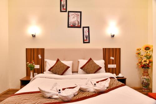 佩林Rufina Palm Bliss的两张位于酒店客房的床,墙上挂着鲜花和图片
