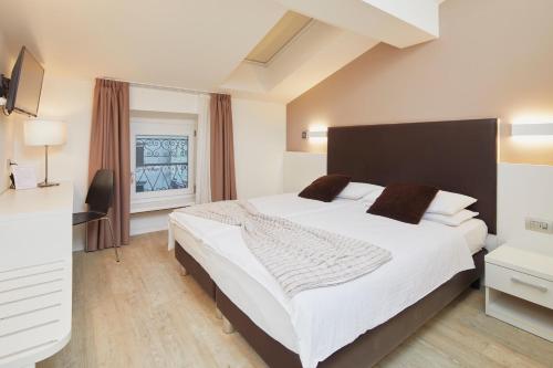 托尔博莱中央酒店的卧室设有一张白色大床和一扇窗户。