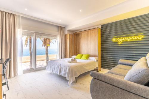 阿尔么丽亚Expoholidays- Apartaments Paseo Marítimo的一间卧室配有一张床、一张沙发和一个窗口