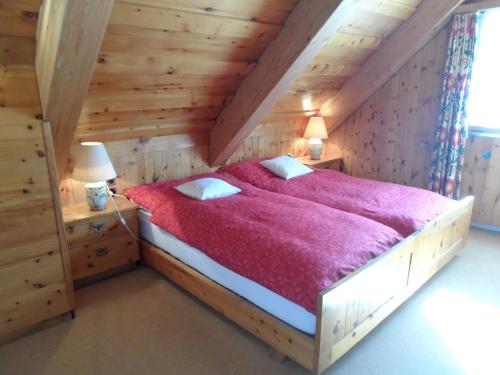 达沃斯阿特里尔木屋酒店的一间卧室配有一张带红色毯子的大床