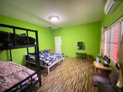 拜县Red orchid pai Thailand的一间卧室设有两张双层床,拥有绿色的墙壁