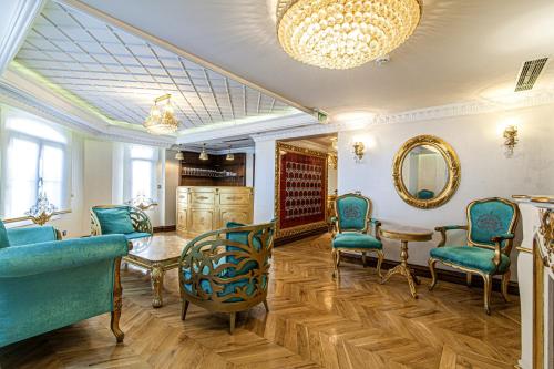 伊斯坦布尔Exquisite Studio in Historic Mansion in Beylerbeyi的沙龙设有蓝色的椅子、桌子和镜子