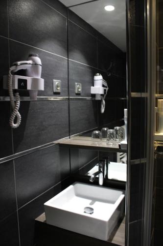 凯恩克洛库斯酒店的一间带白色水槽和电话的浴室