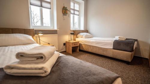 奥尔什丁帕拉斯别墅酒店的配有2张床的客房,设有2扇窗户和毛巾