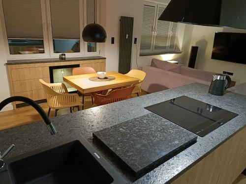 戈尔利采Apartament 3 Maja 4的厨房以及带桌子和沙发的客厅。