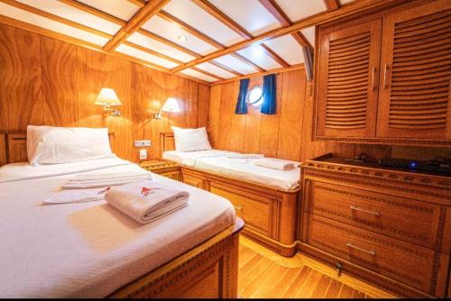 费特希耶Hka Neta Yachting的船屋设有两张床和木制橱柜