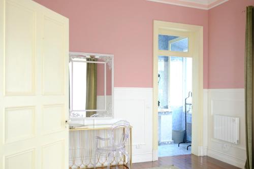 VárzeaVilla Várzea - Garden Suite的一间设有粉红色墙壁、镜子和椅子的房间
