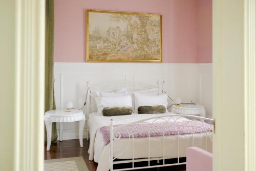 VárzeaVilla Várzea - Garden Suite的卧室配有白色的床和墙上的绘画作品
