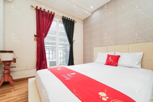 雅加达RedLiving Apartemen Sunter Park View - Emma Rooms的一间卧室配有一张床铺,床上铺有红色毯子