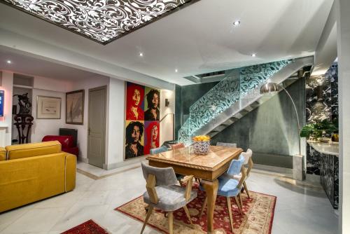 雅典Farmaki Residence, Plaka的一间带桌子和楼梯的用餐室