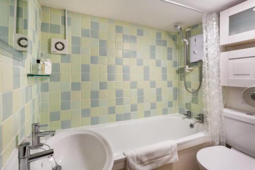斯托昂泽沃尔德Honey Cottage的带浴缸、卫生间和盥洗盆的浴室