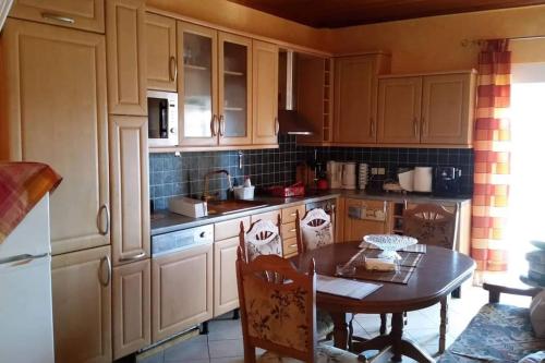 Mama Sofia's house的厨房配有木制橱柜和桌椅