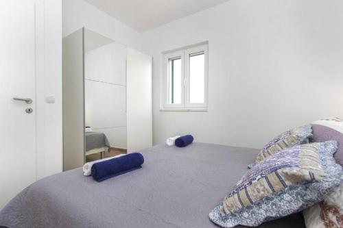 克拉帕尼岛Riva 2的一间卧室配有一张带蓝色枕头的床和一扇窗户。