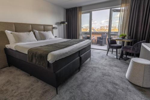 德科赫特克塞尔果岭酒店的酒店客房设有一张大床和一个阳台。