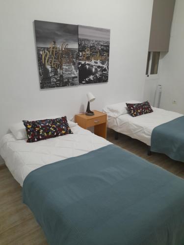 圣克鲁斯-德特内里费San Sebastián 65的卧室配有两张床,墙上挂着一幅画
