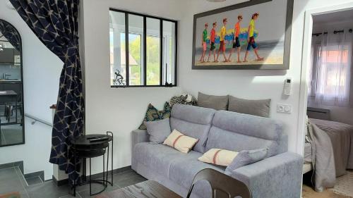 旧阿讷西Le Refuge, 2 personnes, 4 étoiles tout confort的客厅配有灰色沙发和绘画